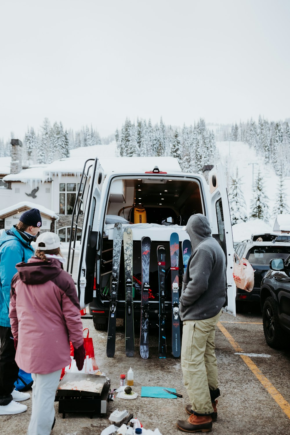 a group of people loading skis into the back of a van