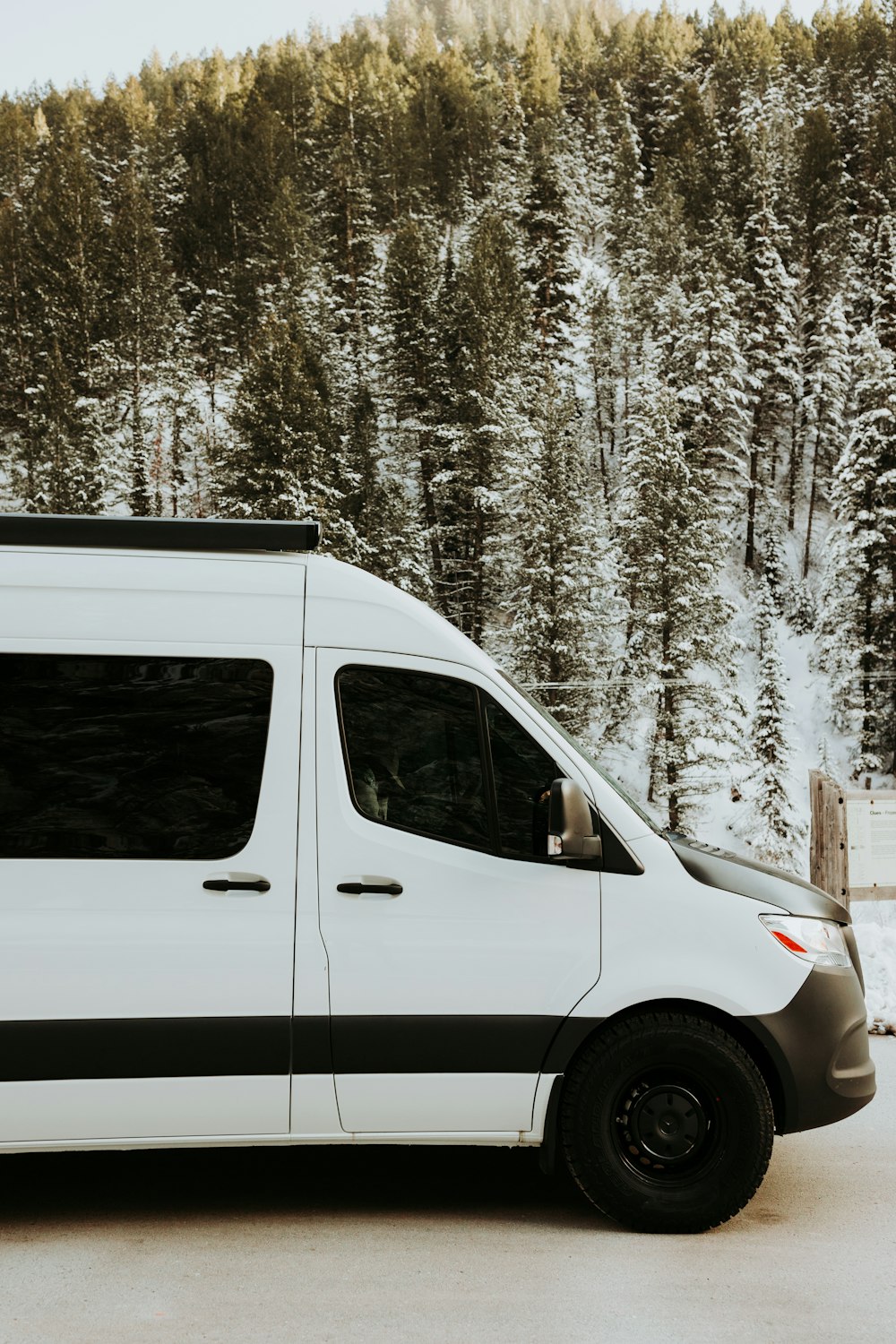 a white van parked in front of a forest