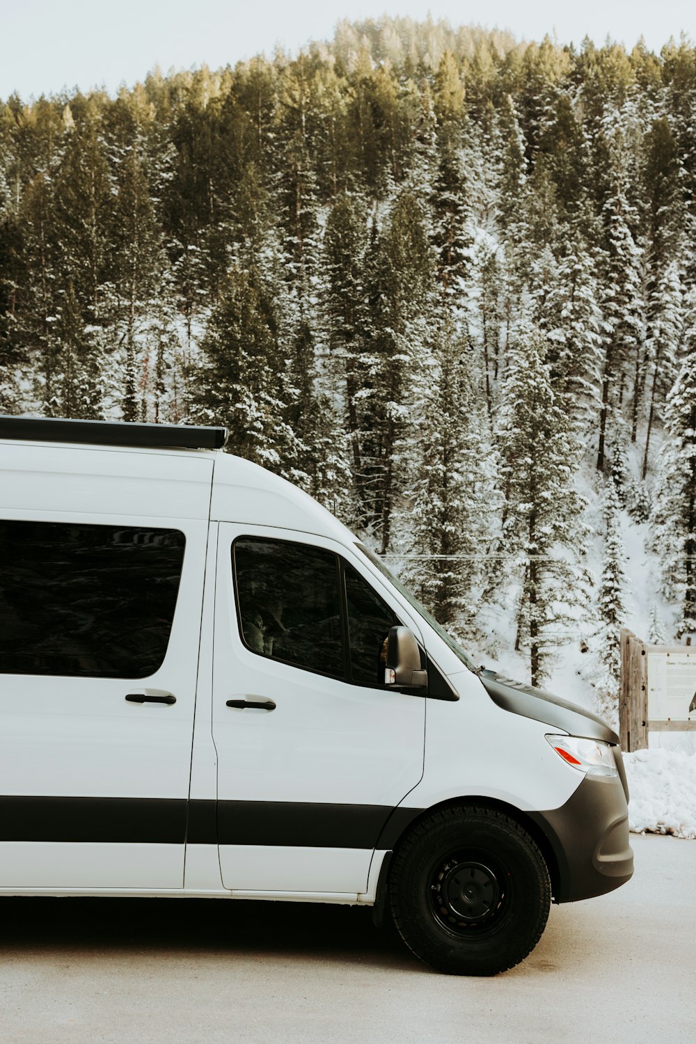 a white van parked in front of a forest