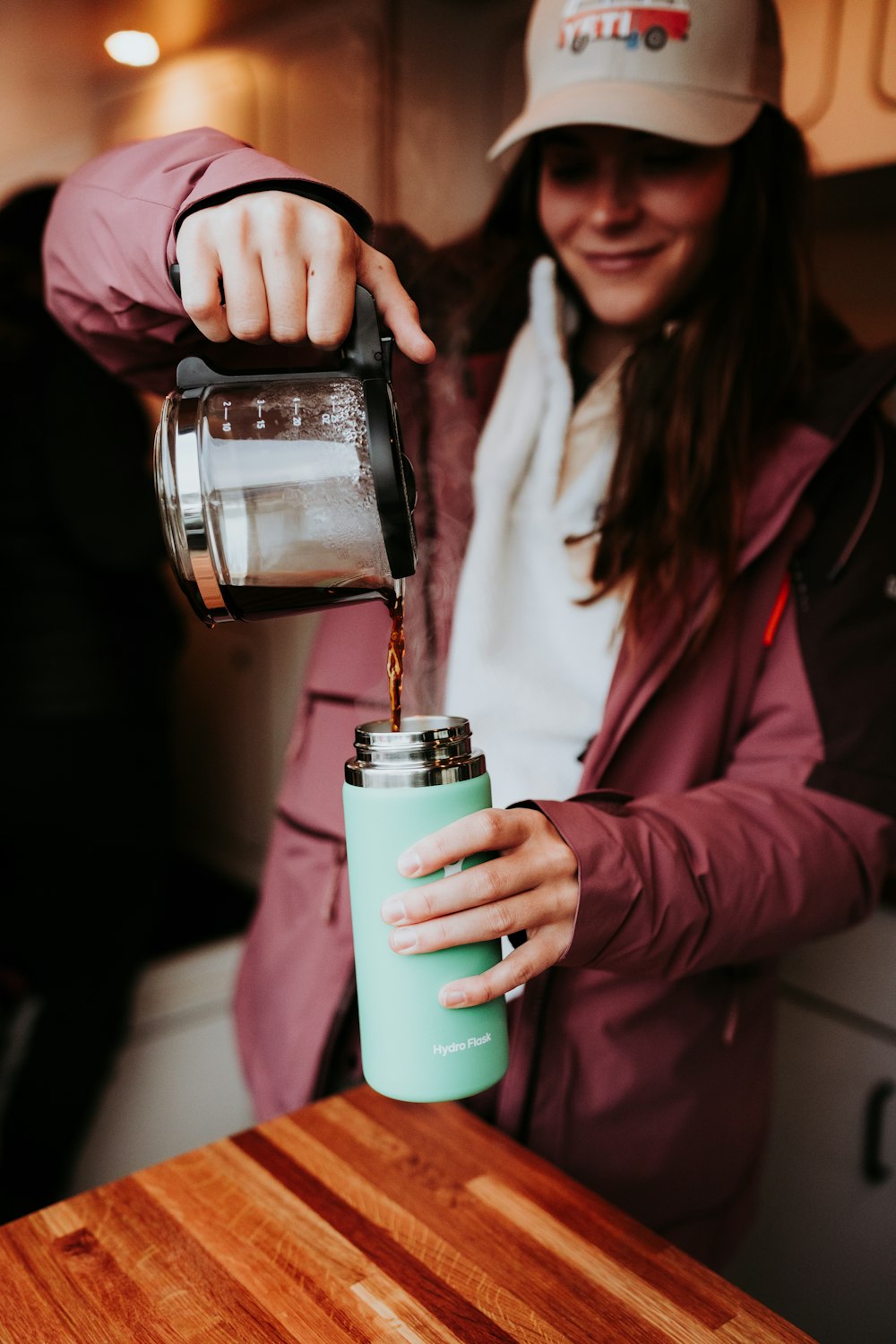 Eine Frau gießt Kaffee in eine Tasse