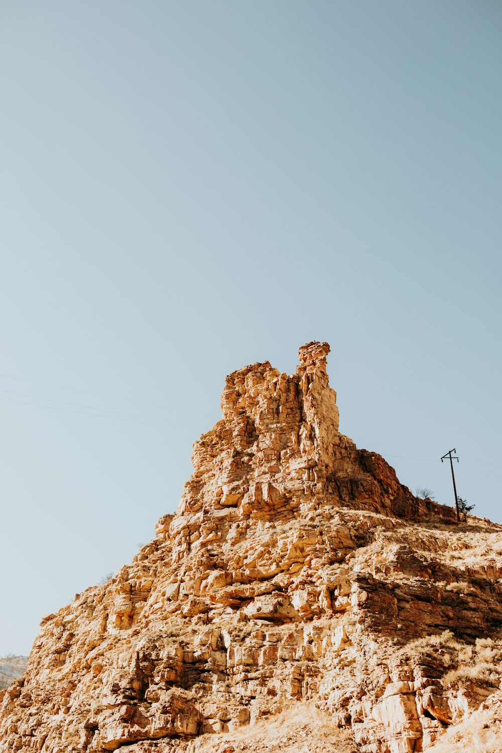 a tall rock formation with a sky background