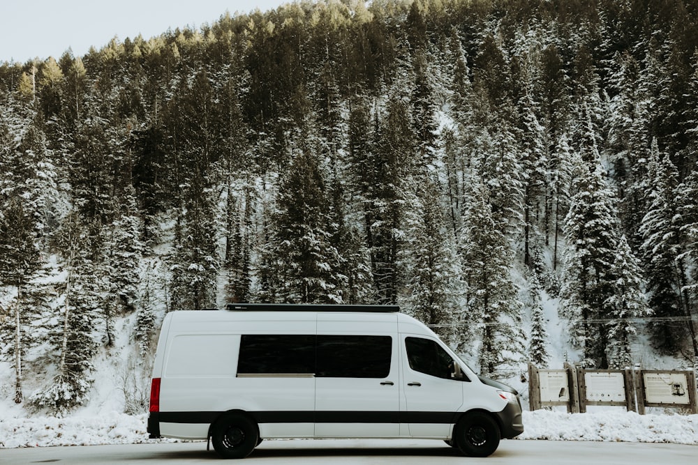 a white van driving down a snow covered road