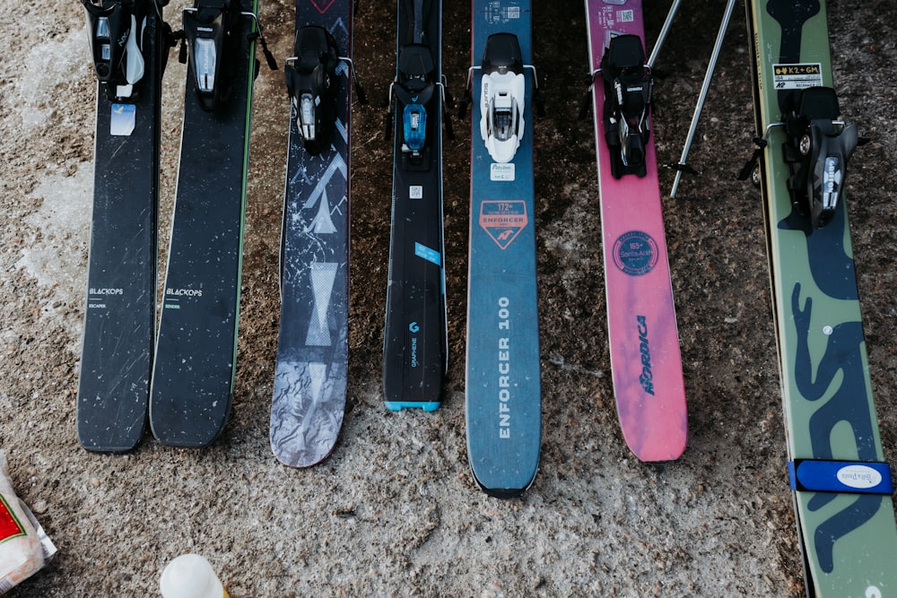 a group of snowboards and skis laying on the ground