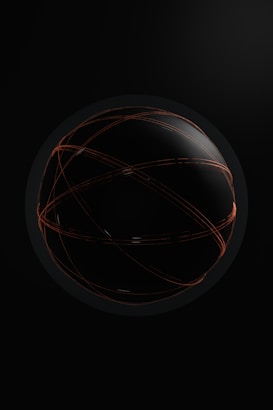 A dark spherical object with glowing orange lines crisscrossing its surface, set against a black background. The lines give an impression of movement and energy.