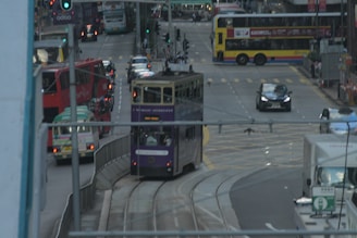 A busy city street with various public transport vehicles.