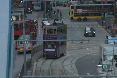 A busy city street with various public transport vehicles.