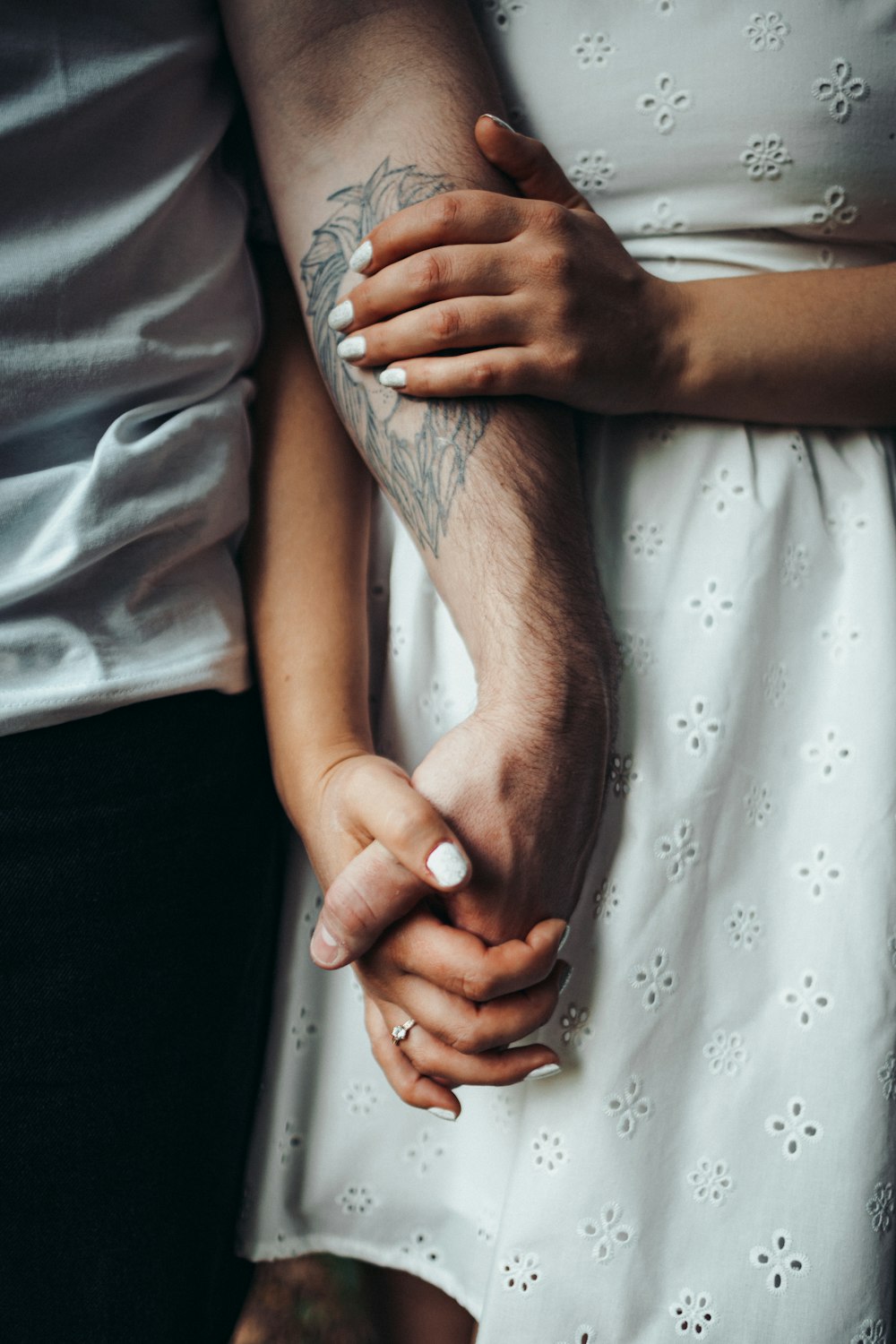 a close up of two people holding hands