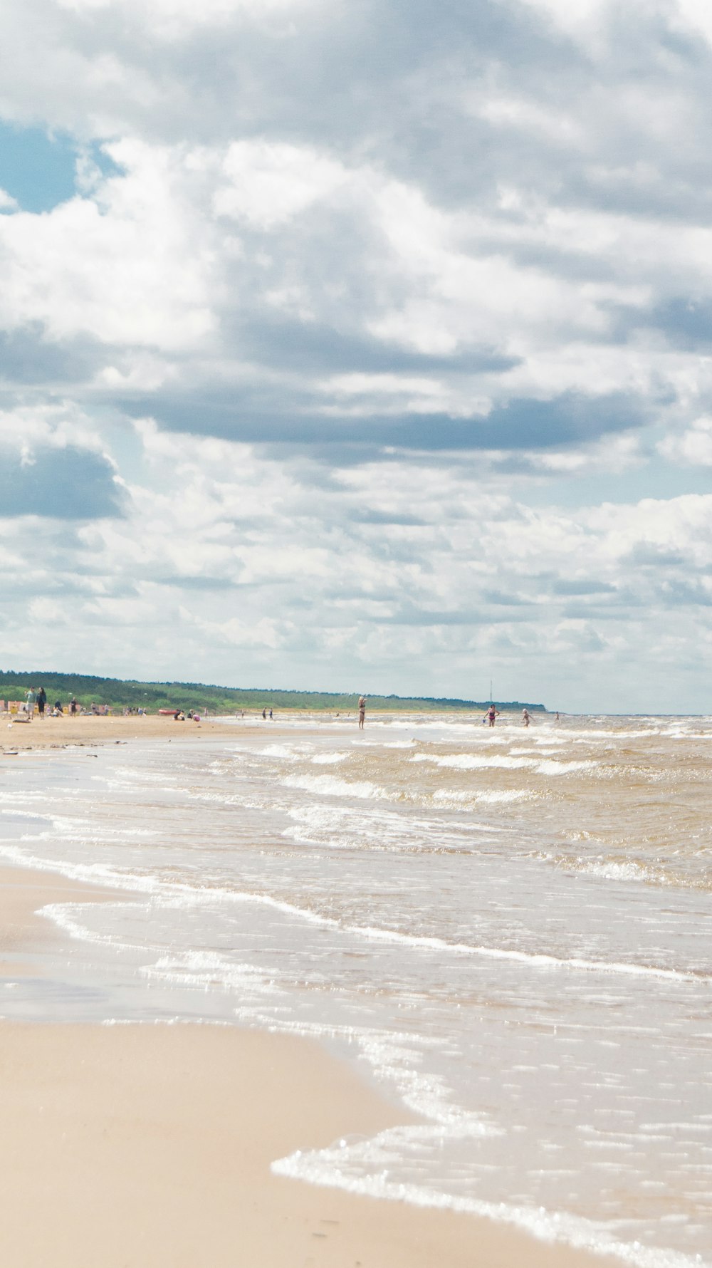 a group of people standing on top of a sandy beach