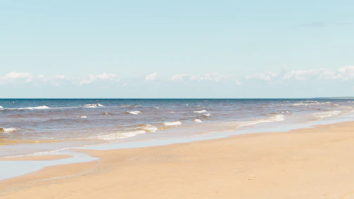 Wide-angle shot of a serene beach with gentle waves.