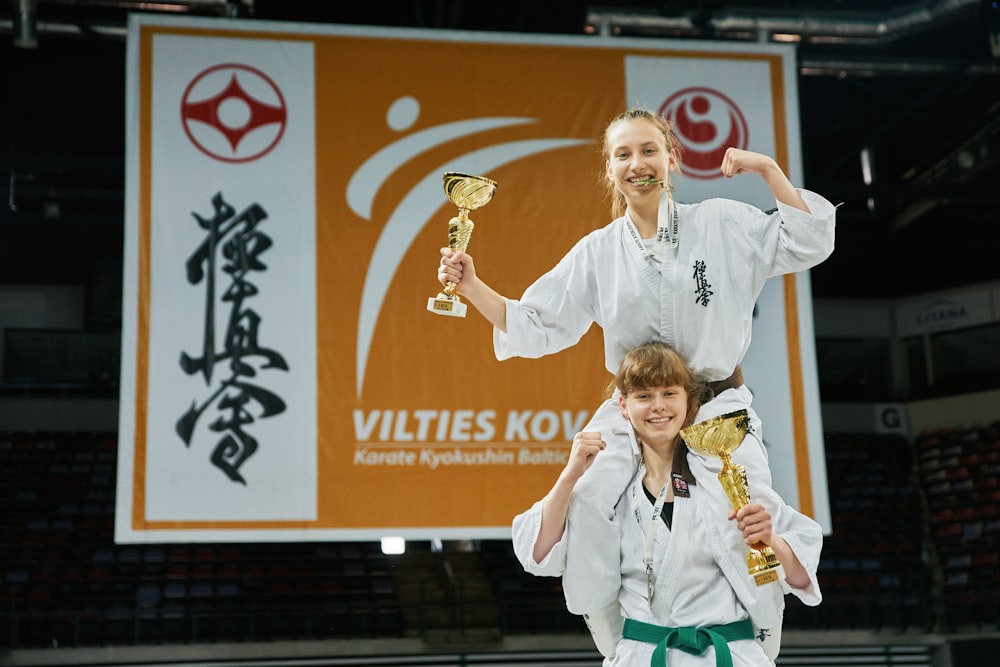 a woman holding a trophy while standing next to a man