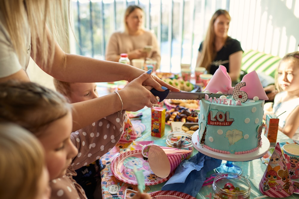 a group of people sitting around a table with a cake