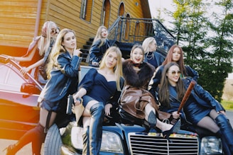a group of women sitting on top of a car