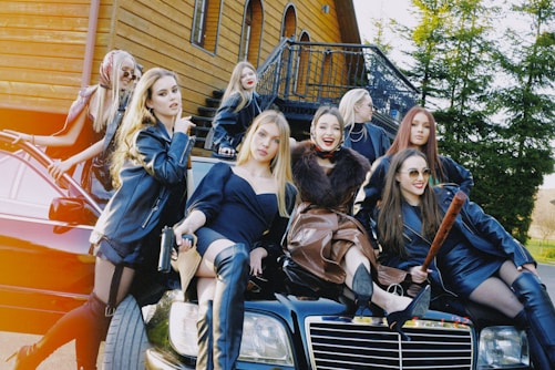 a group of women sitting on top of a car