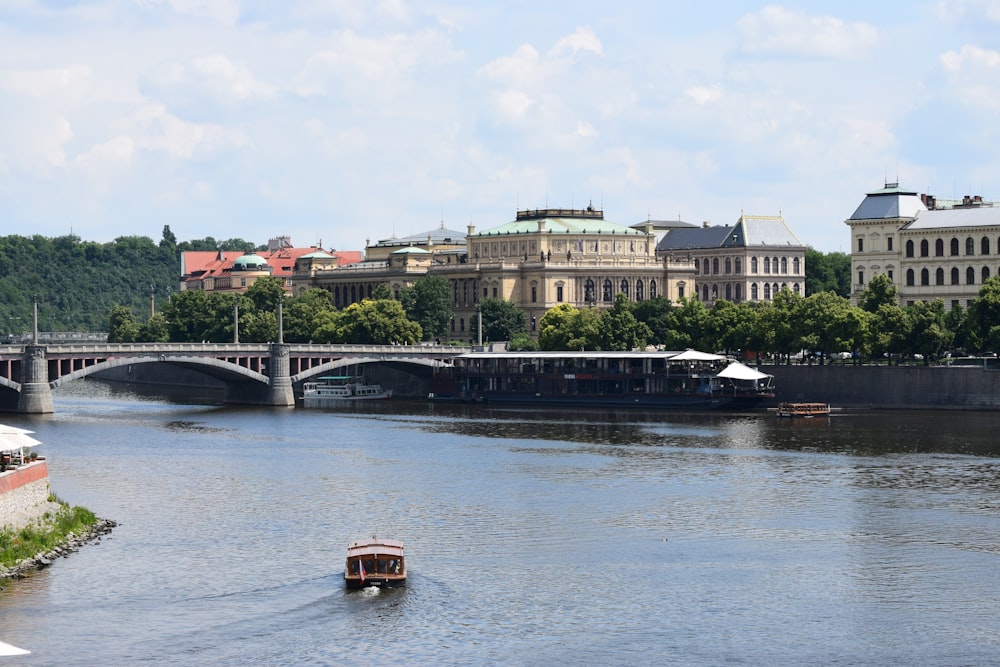 a boat traveling down a river next to a bridge