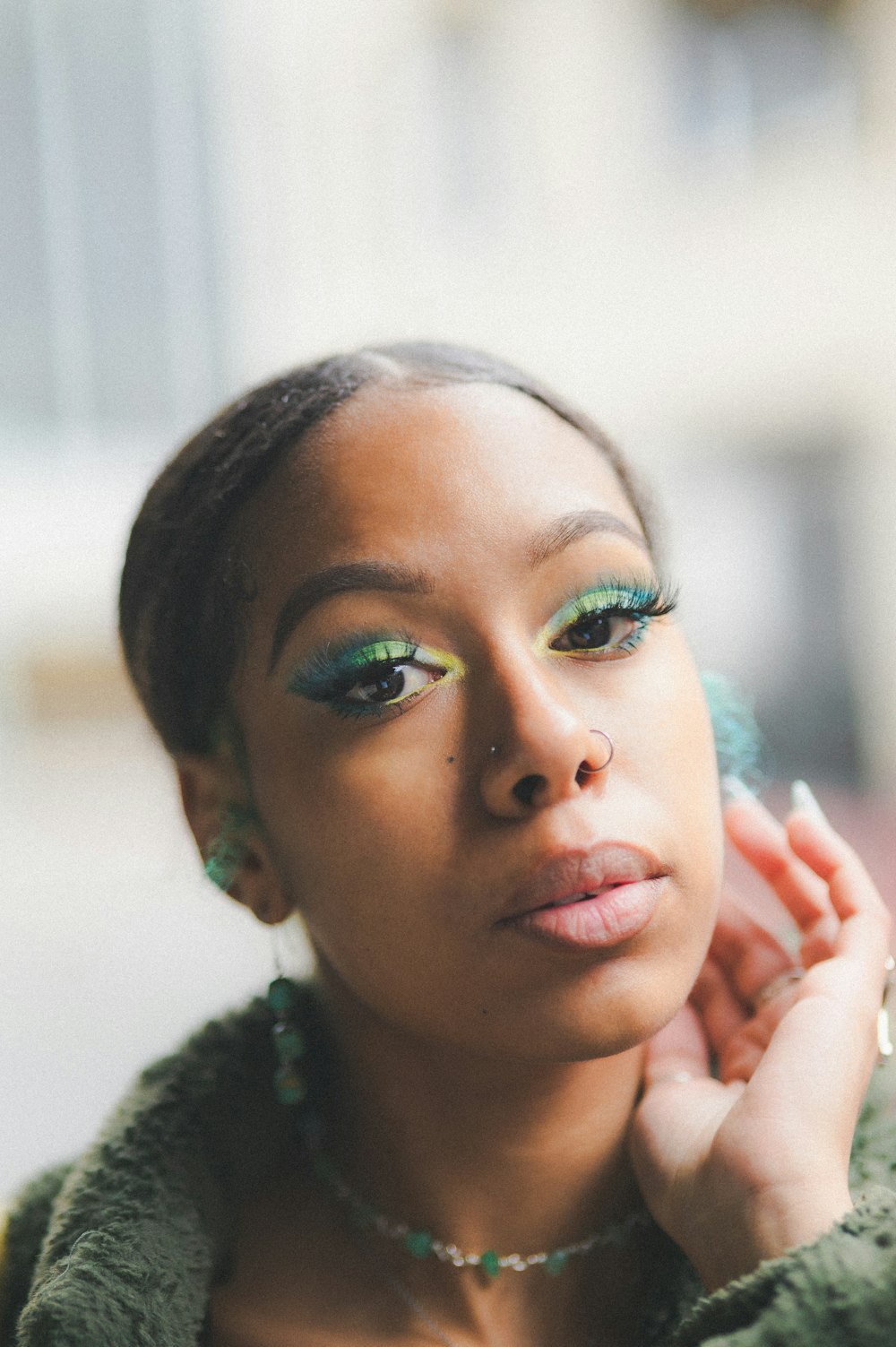 a woman with green eyeshades and a green jacket