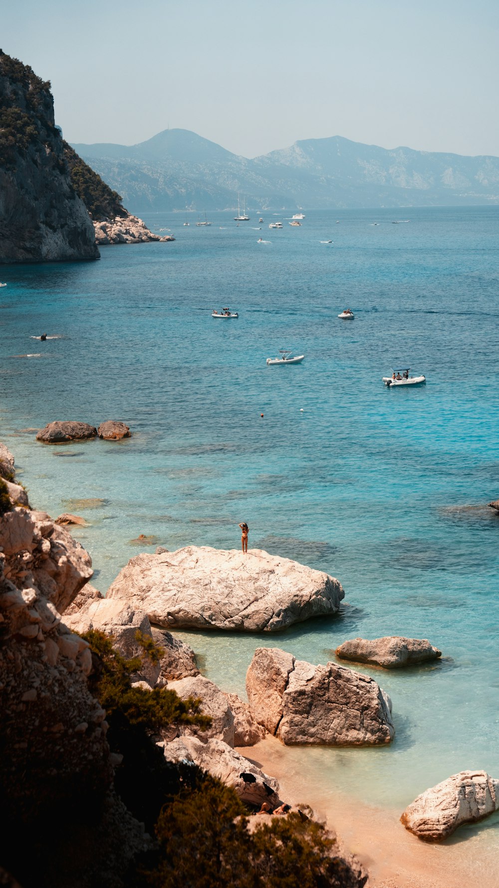 a person standing on a beach next to a body of water