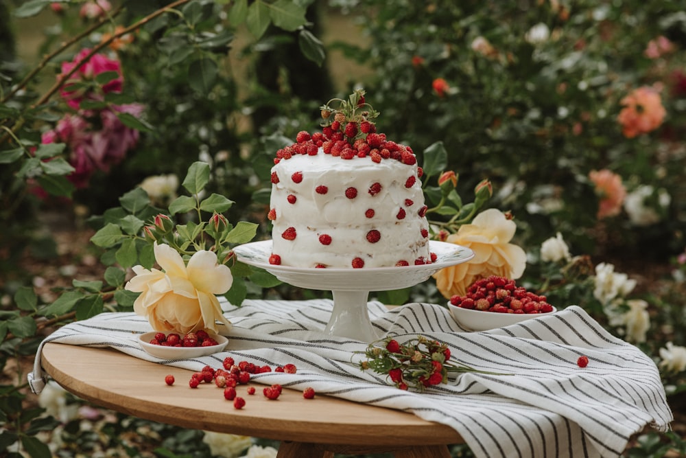 una torta su un tavolo con fiori sullo sfondo