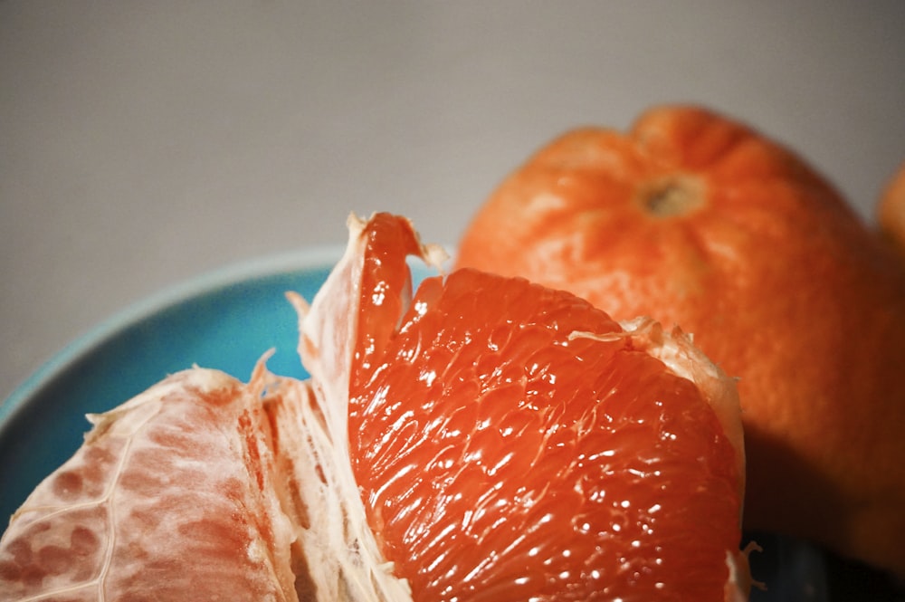uma laranja descascada sentada em cima de um prato azul