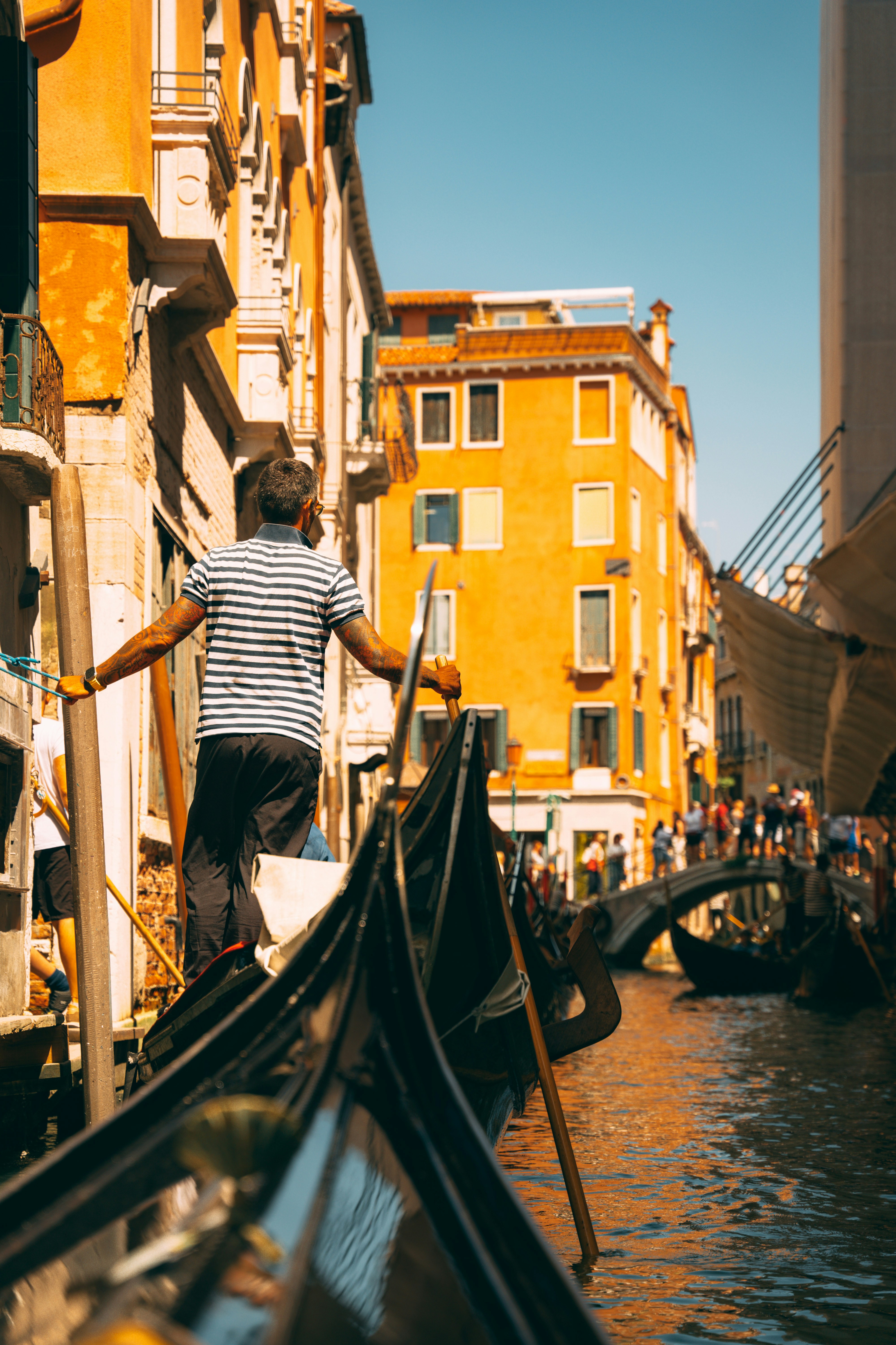 a man riding a gondola down a street next to tall buildings