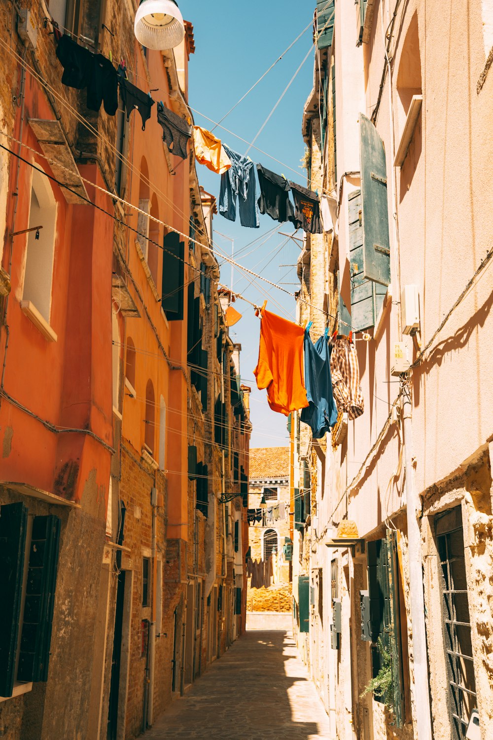 a narrow alley way with clothes hanging on a line