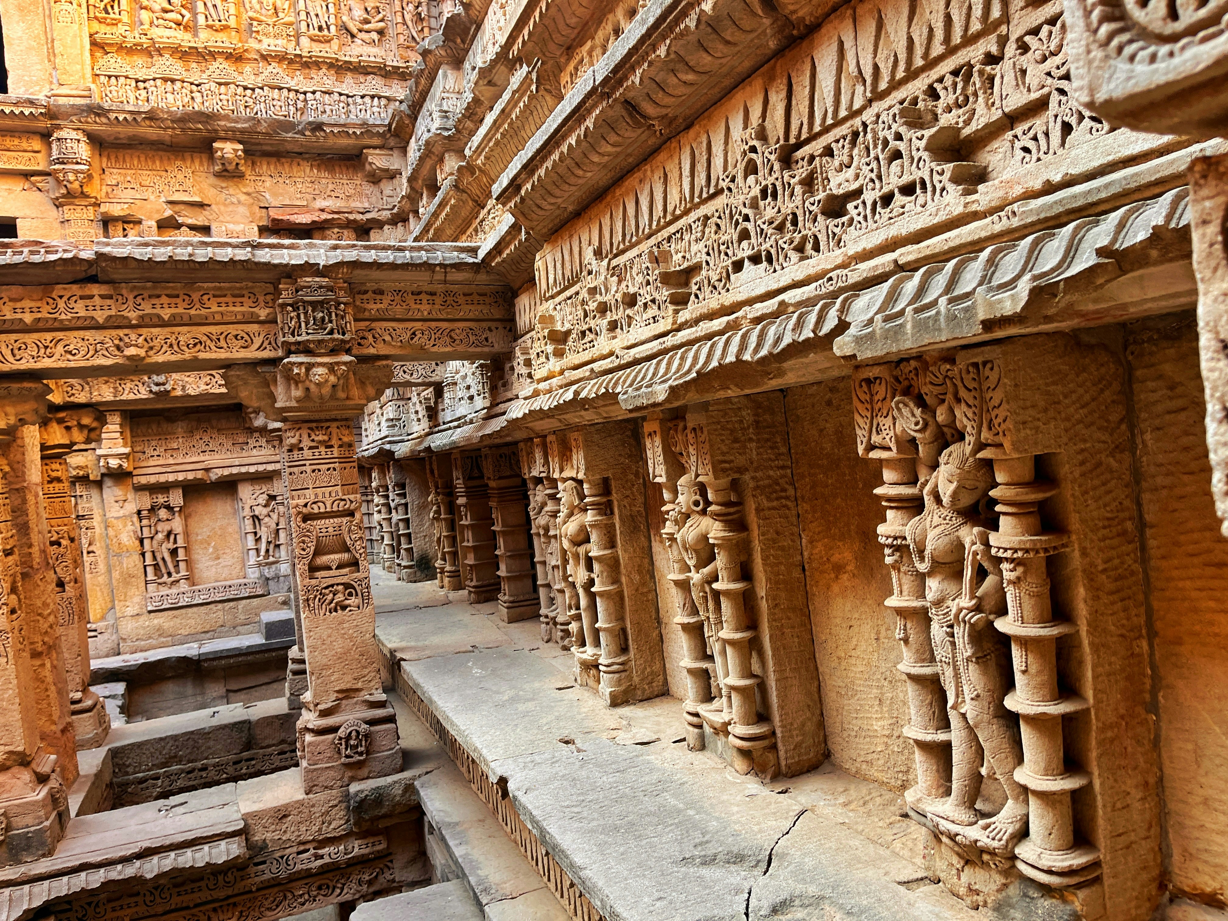 Adalaj stepwell in Ahmedabad with ornate carved stone corridors and geometric patterns in warm afternoon light