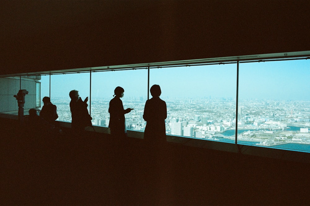 a group of people standing in front of a window