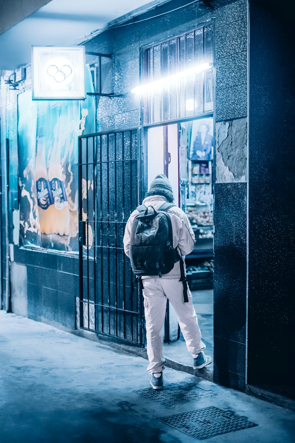 a man with a backpack is standing on the sidewalk