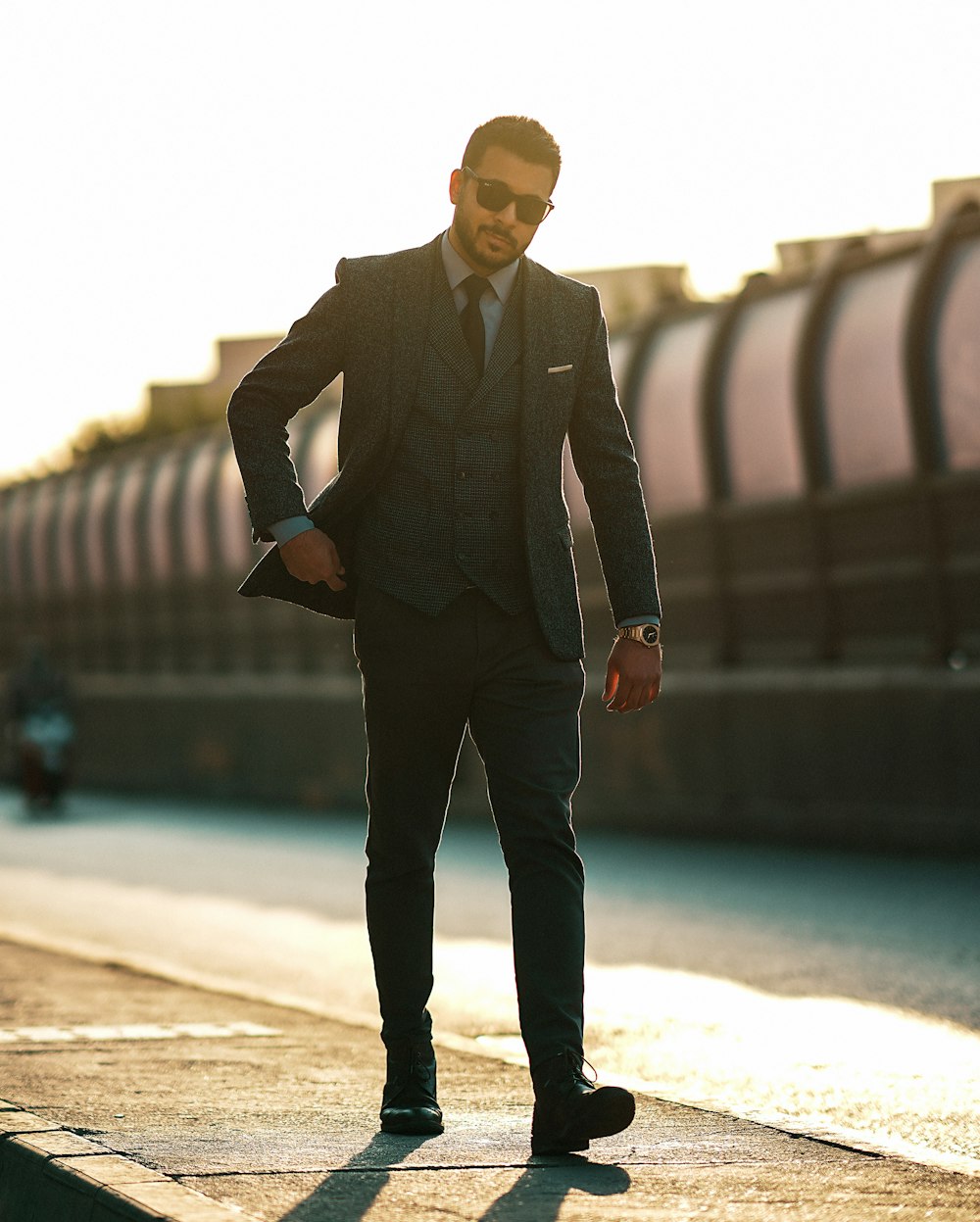 a man in a suit standing on a sidewalk