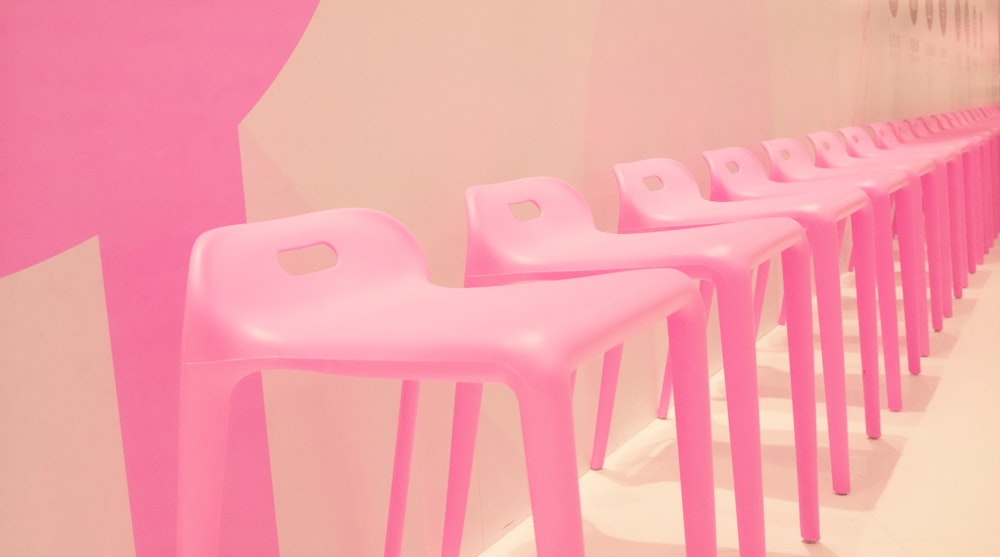 a row of pink chairs sitting next to each other