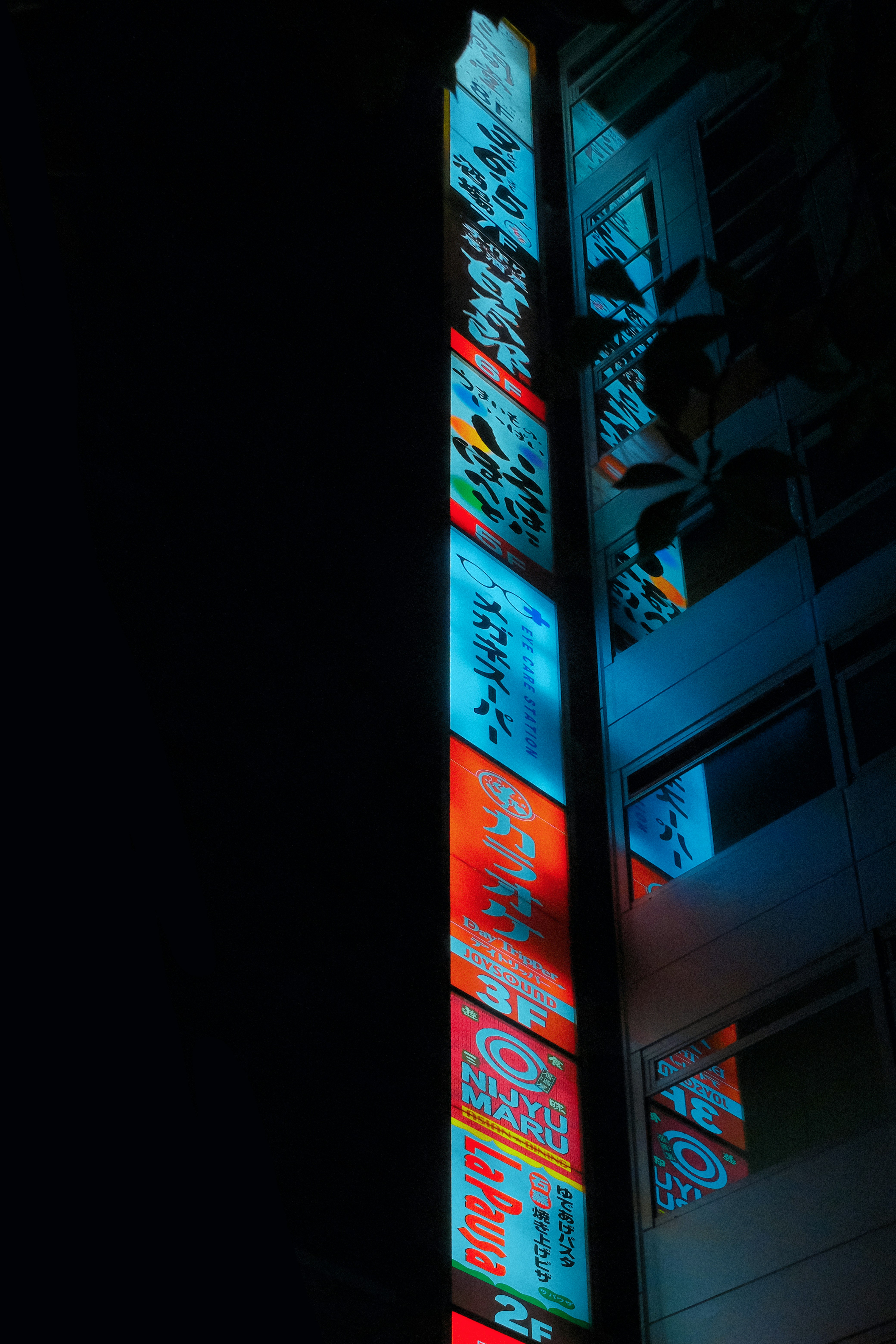 a tall building with a lot of windows lit up at night