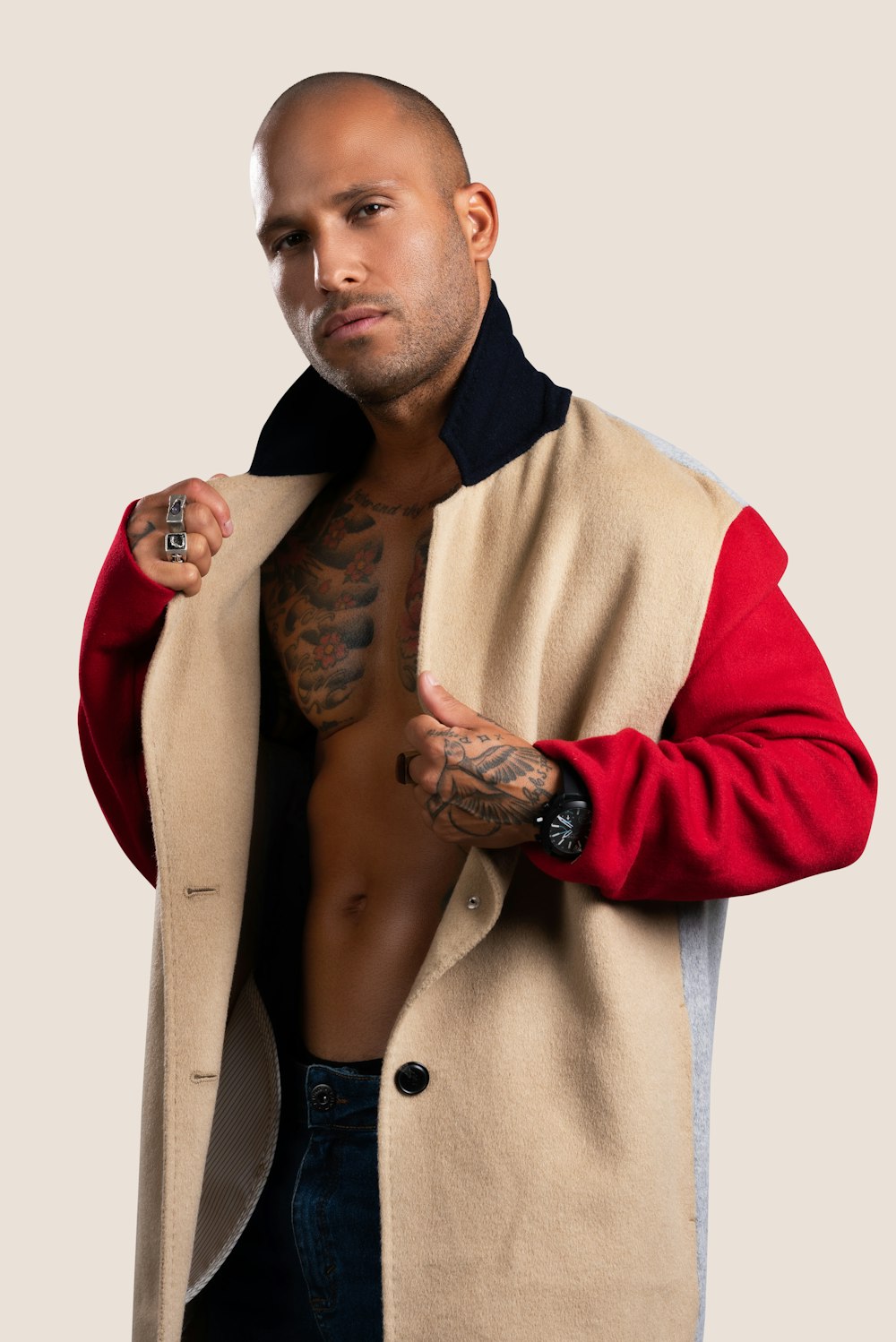 a man with a tattoo on his arm wearing a jacket