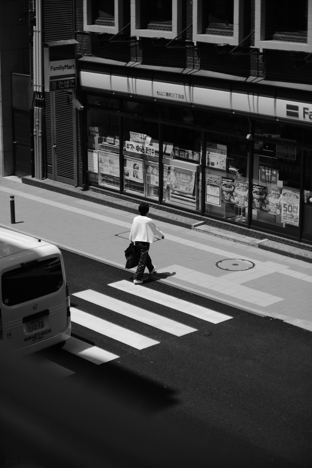 a man walking across a street next to a cross walk