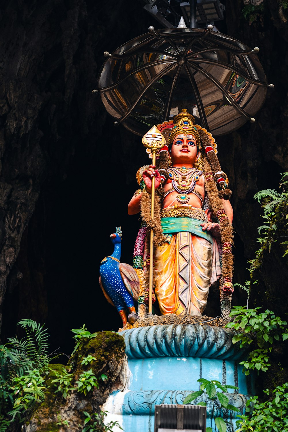 a statue of a woman holding a bird in a cave