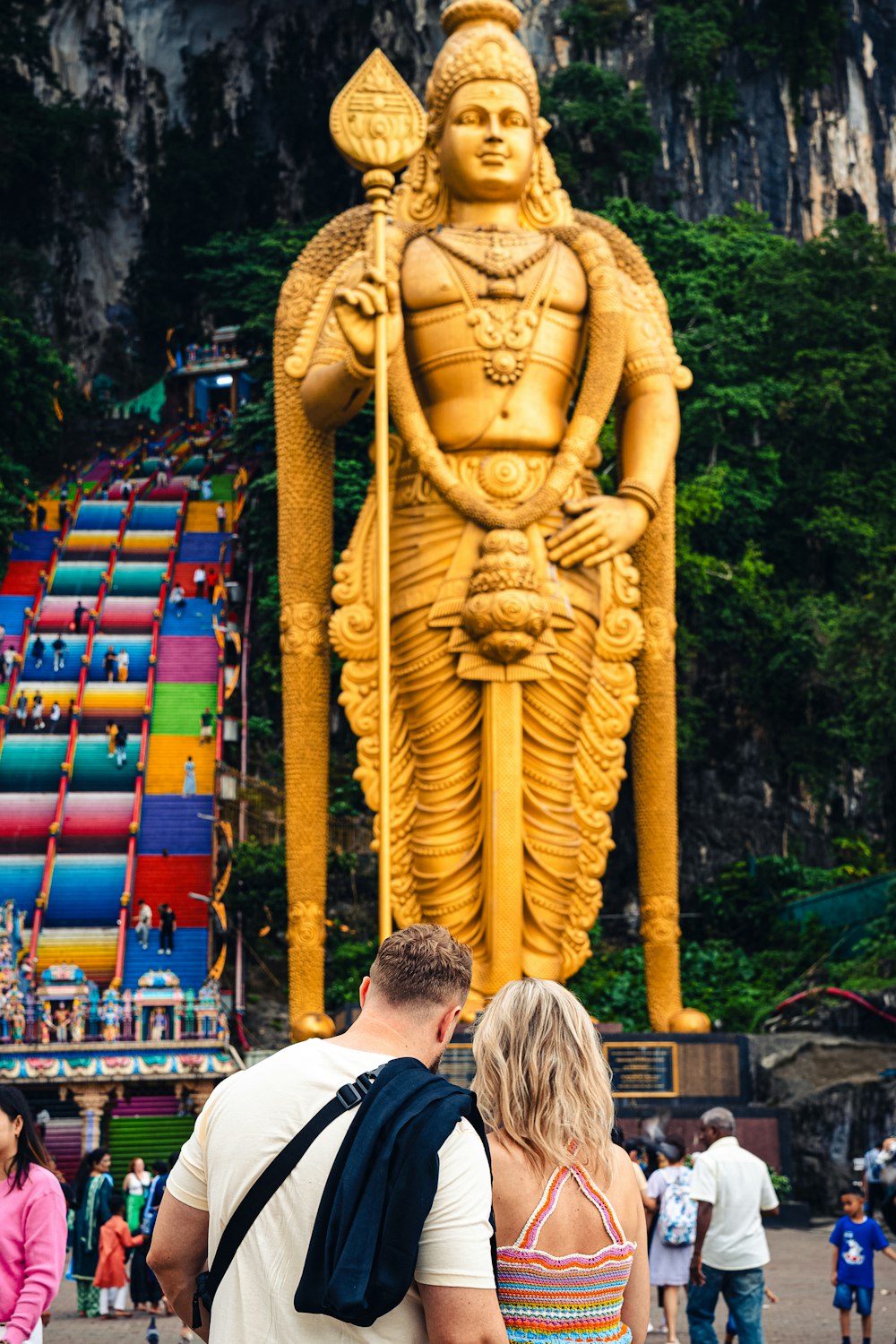 a man and a woman standing in front of a giant statue