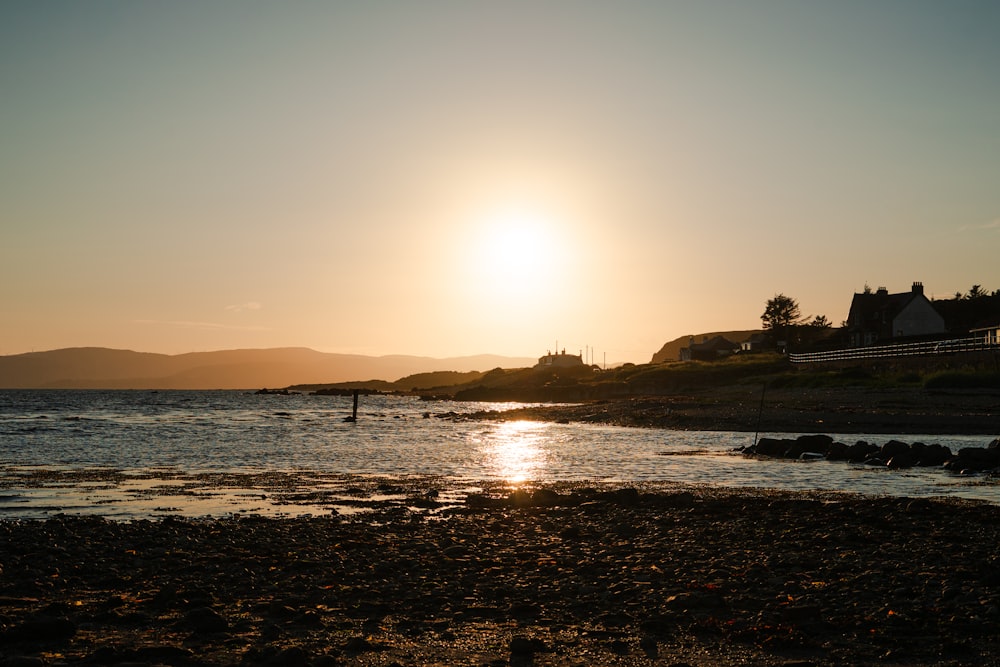 the sun is setting over a body of water