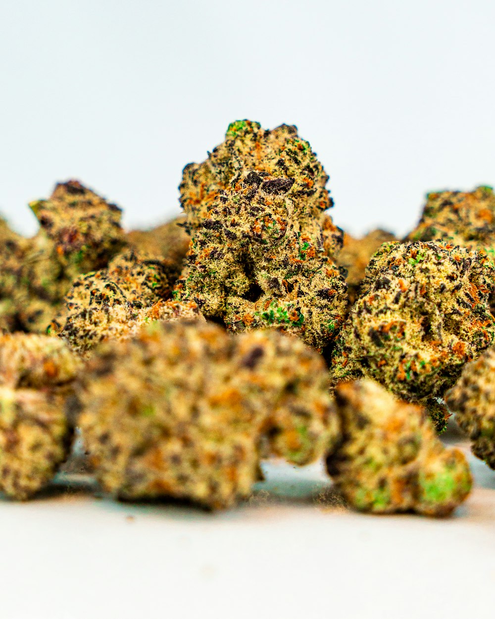 a pile of marijuana buds sitting on top of a white table