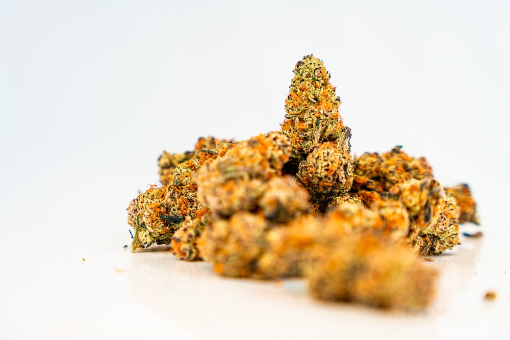 a pile of orange weed sitting on top of a white table