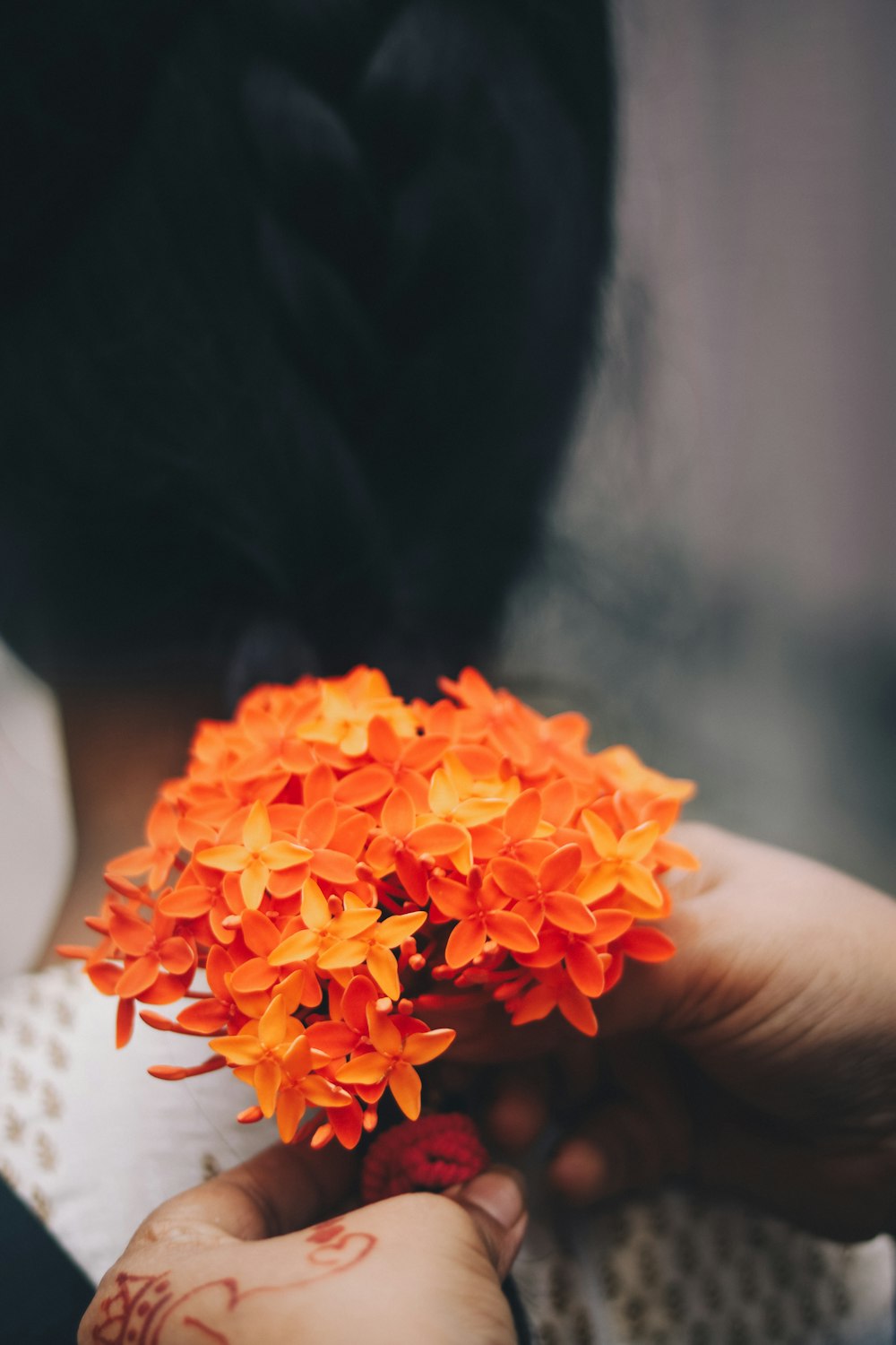 a woman holding a bunch of orange flowers