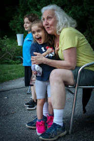 a woman sitting on a chair next to a little boy