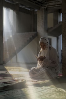 a woman sitting on the floor reading a book