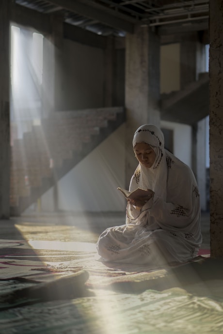 a woman sitting on the floor reading a book