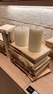An artistic shot of vintage mystical books stacked with candles around.
