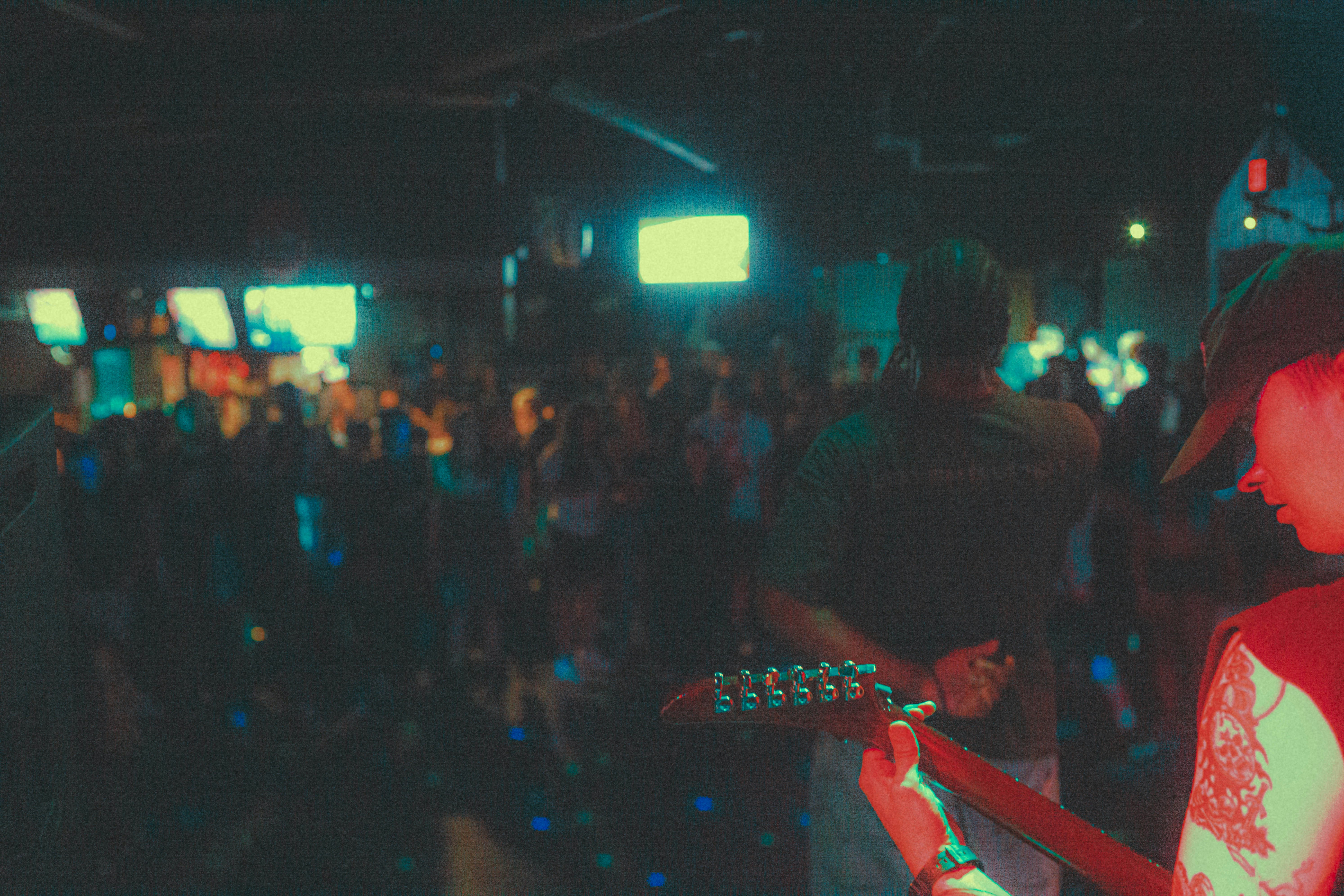 a man playing a guitar in a crowded room