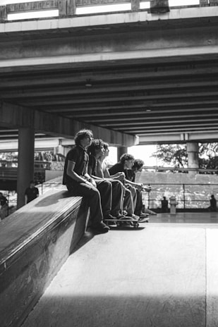 A group of young people wearing gearfourth shoes, hanging out and laughing near a skate park.