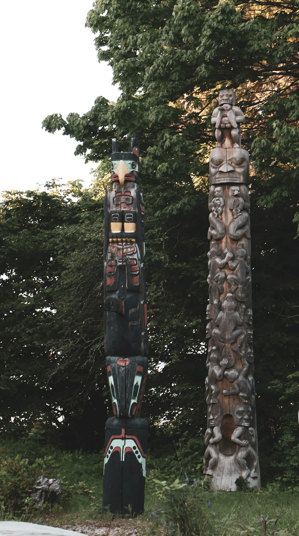 a totem stands next to a tall tree