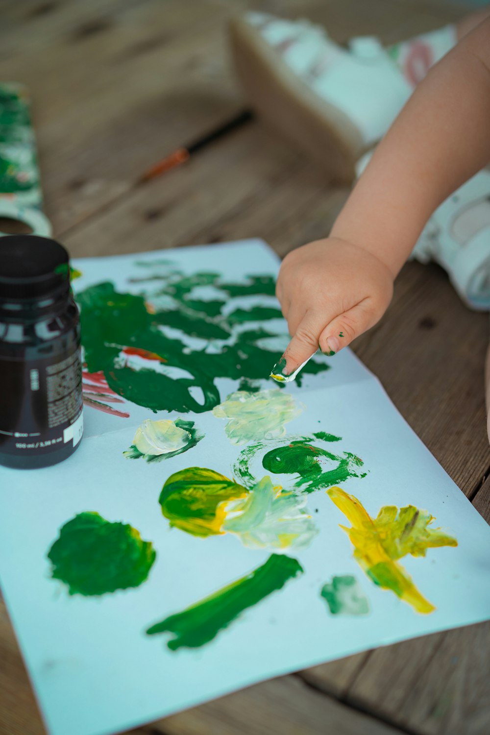 a child is painting on a piece of paper