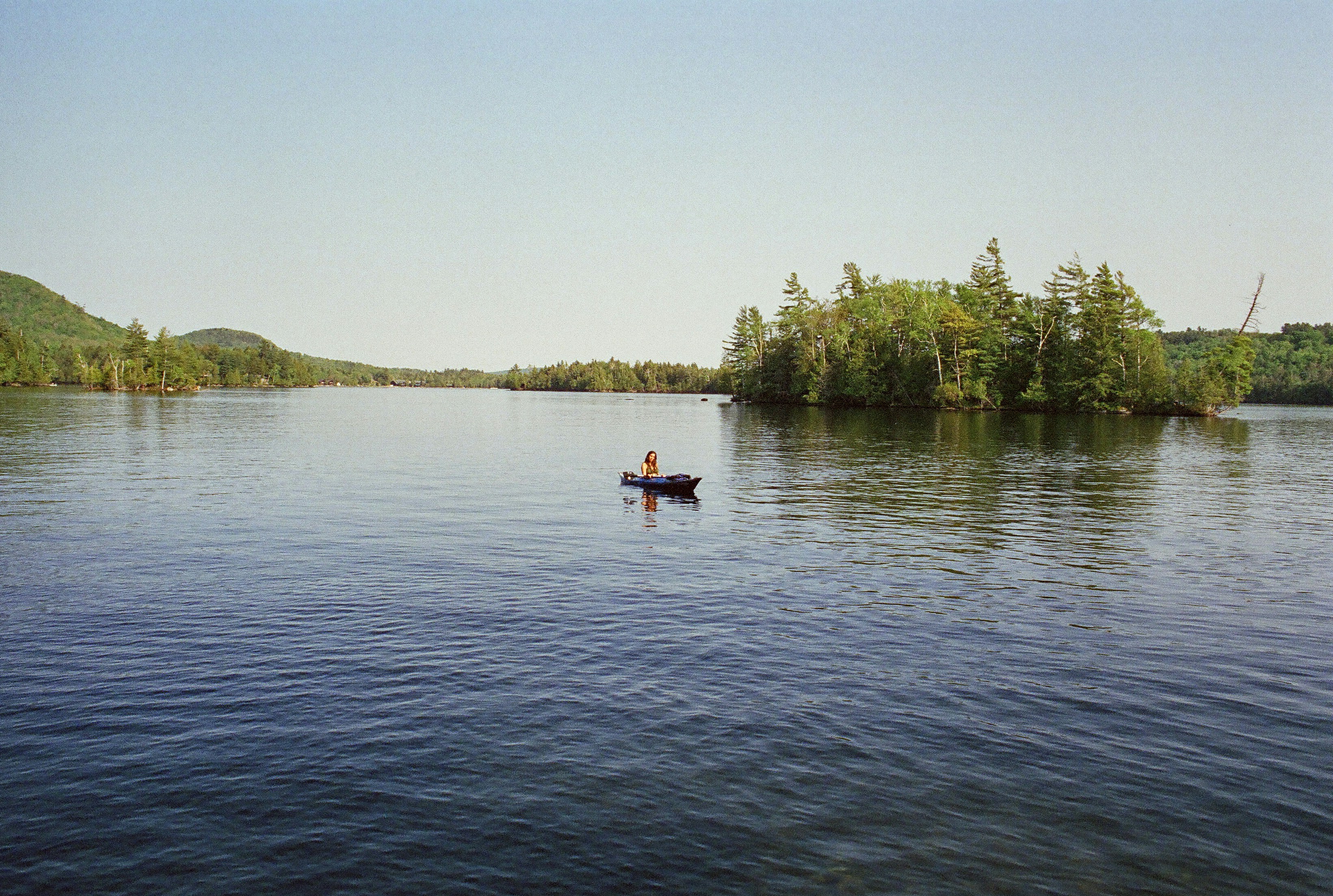 a person in a small boat on a lake, 