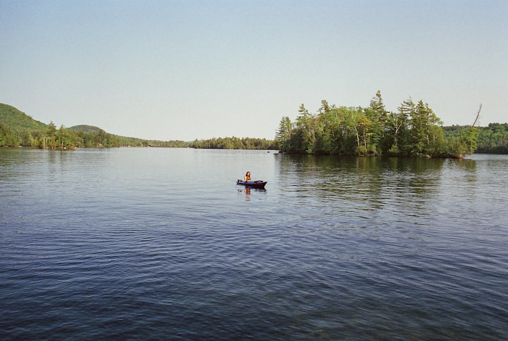 a person in a small boat on a lake