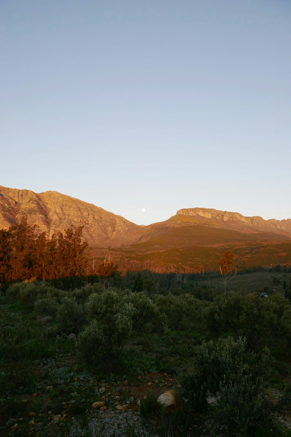 uma vista de uma cordilheira ao pôr do sol