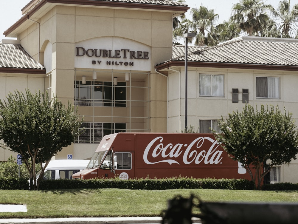 a coca - cola truck is parked in front of a hotel